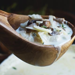 Low-Carb Cheese Soup with Mushrooms and Thyme in a ladle