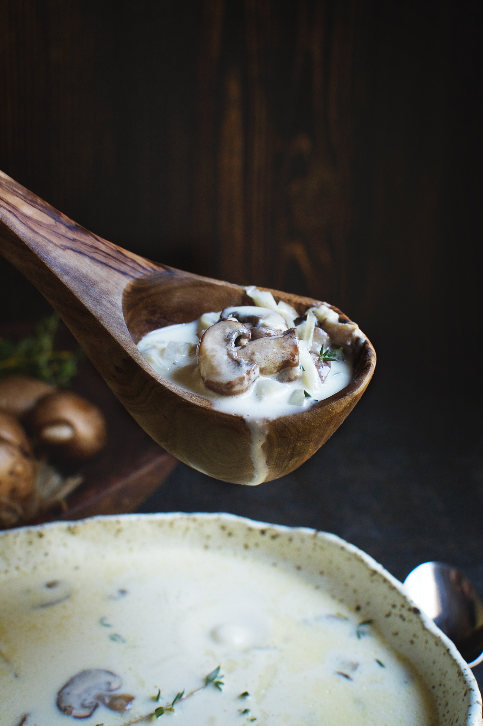 Low-Carb Cheese Soup with Mushrooms and Thyme in a ladle