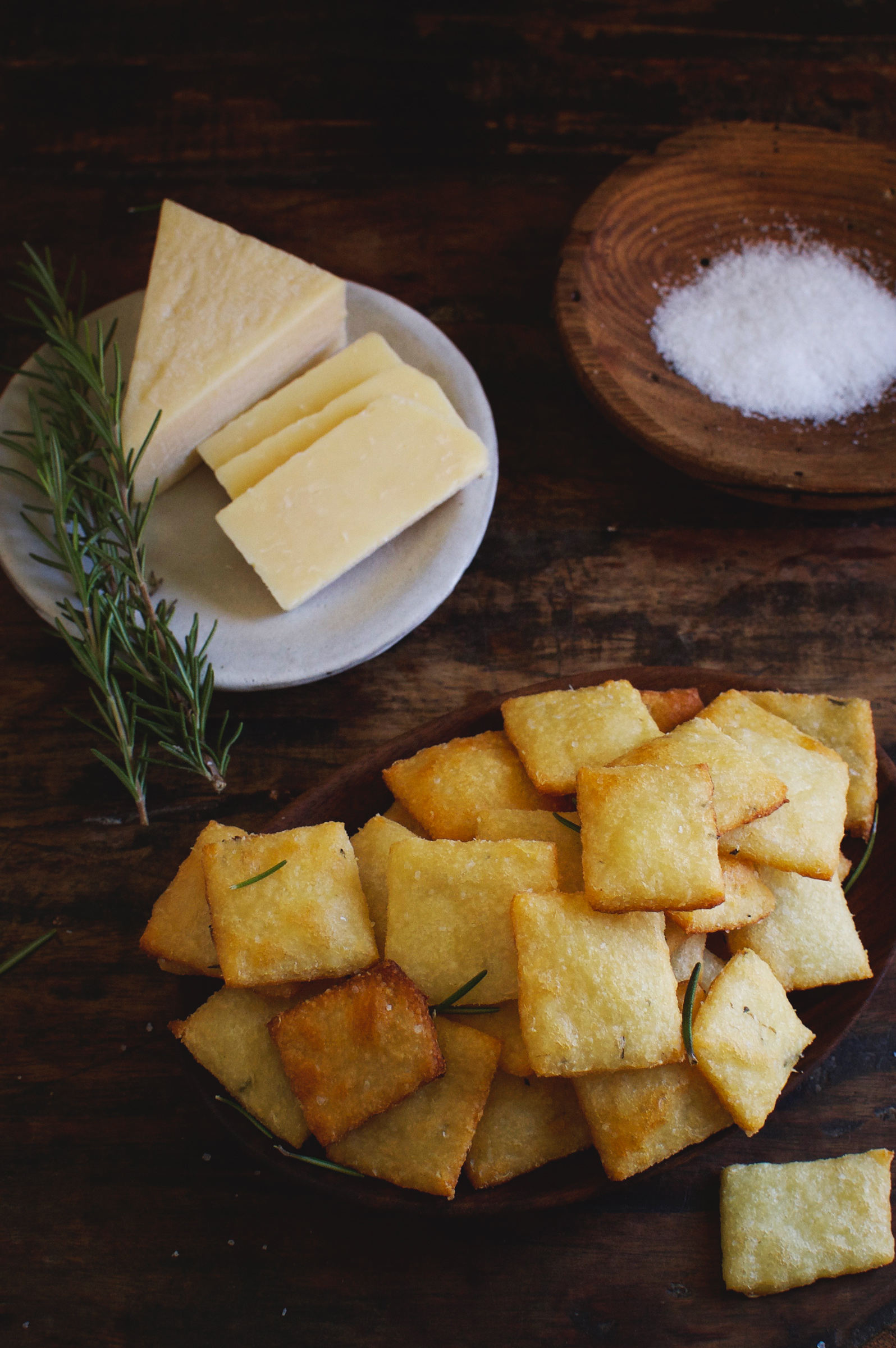 Low-Carb Rosemary Parmesan Crackers shown with rosemary, salt, and cheese.