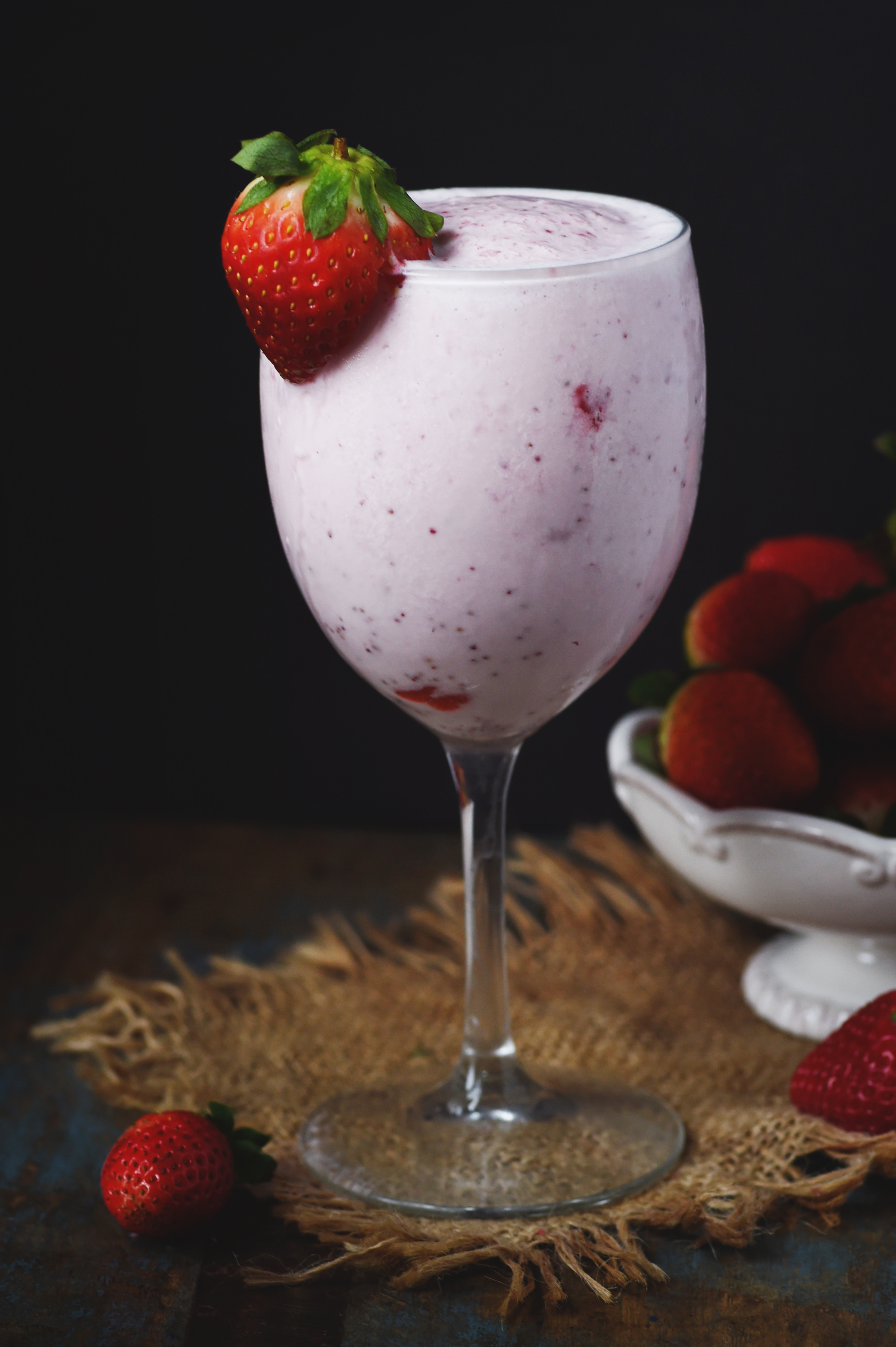 Low-Carb Strawberry Smoothie in a wine glass with a strawberry garnish.
