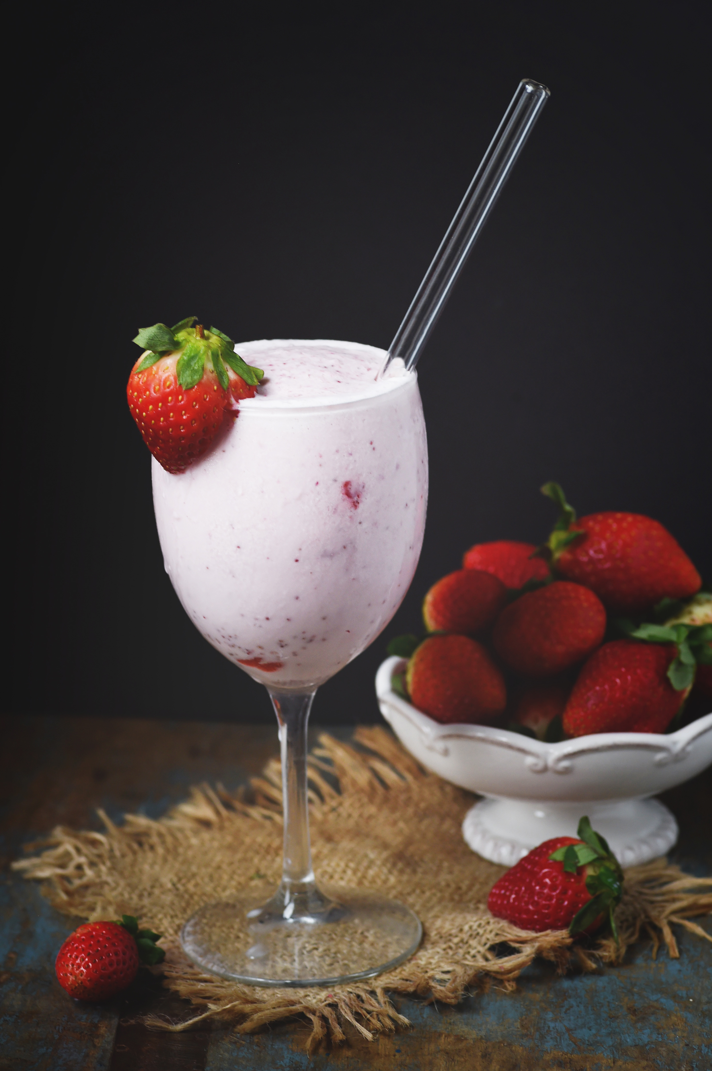 Low-Carb Strawberry Smoothie in a wine glass with a straw.