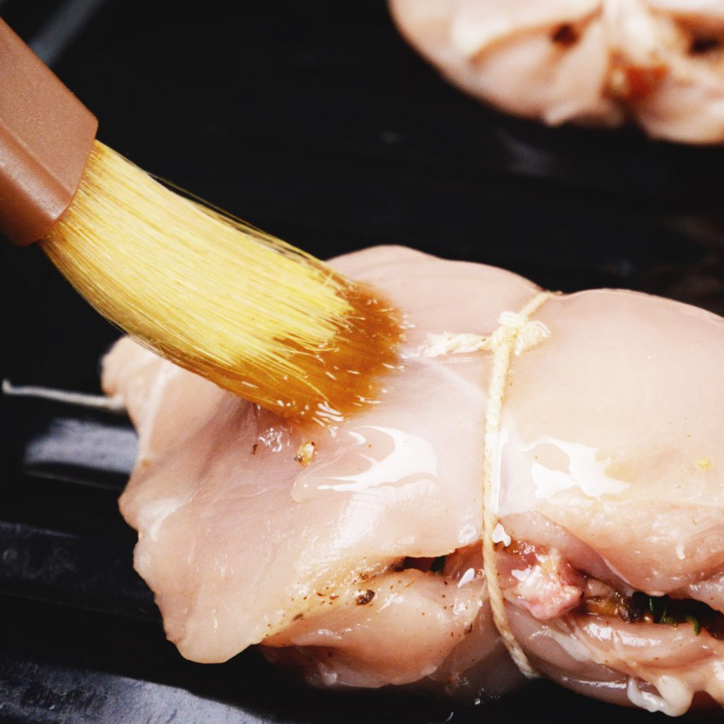 Mushroom and Bacon Stuffed Chicken Breasts-Brushing with oil.
