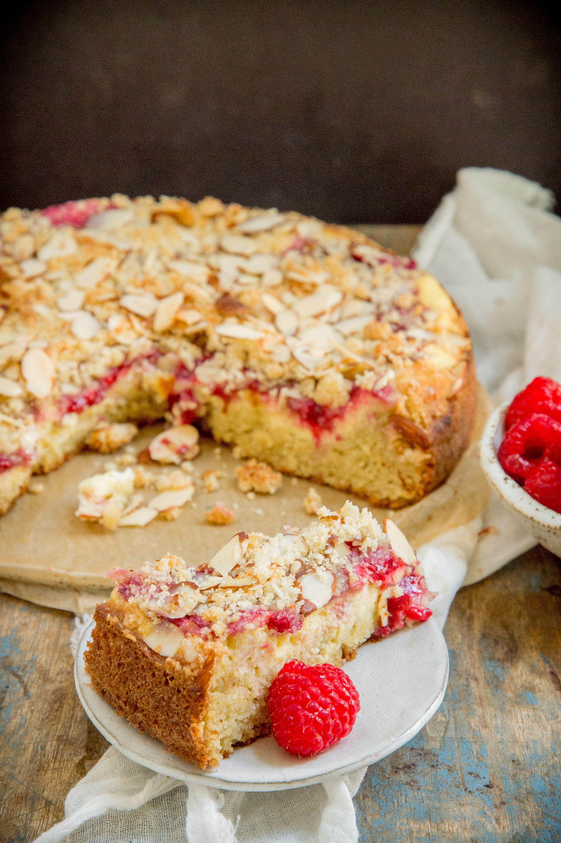 Keto Raspberry Cream Cheese Coffee Cake-A piece with the rest of the cake in the background.