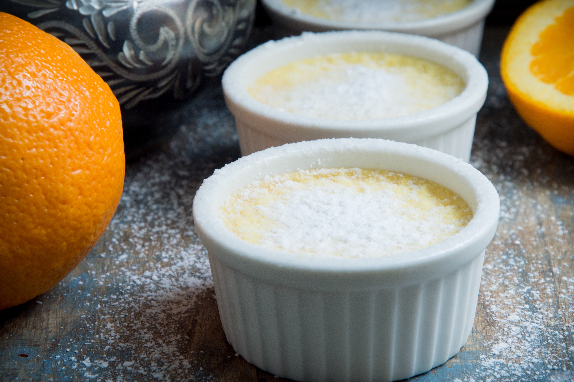 Dusting Low-Carb Orange Pots de Crème with sweetener.