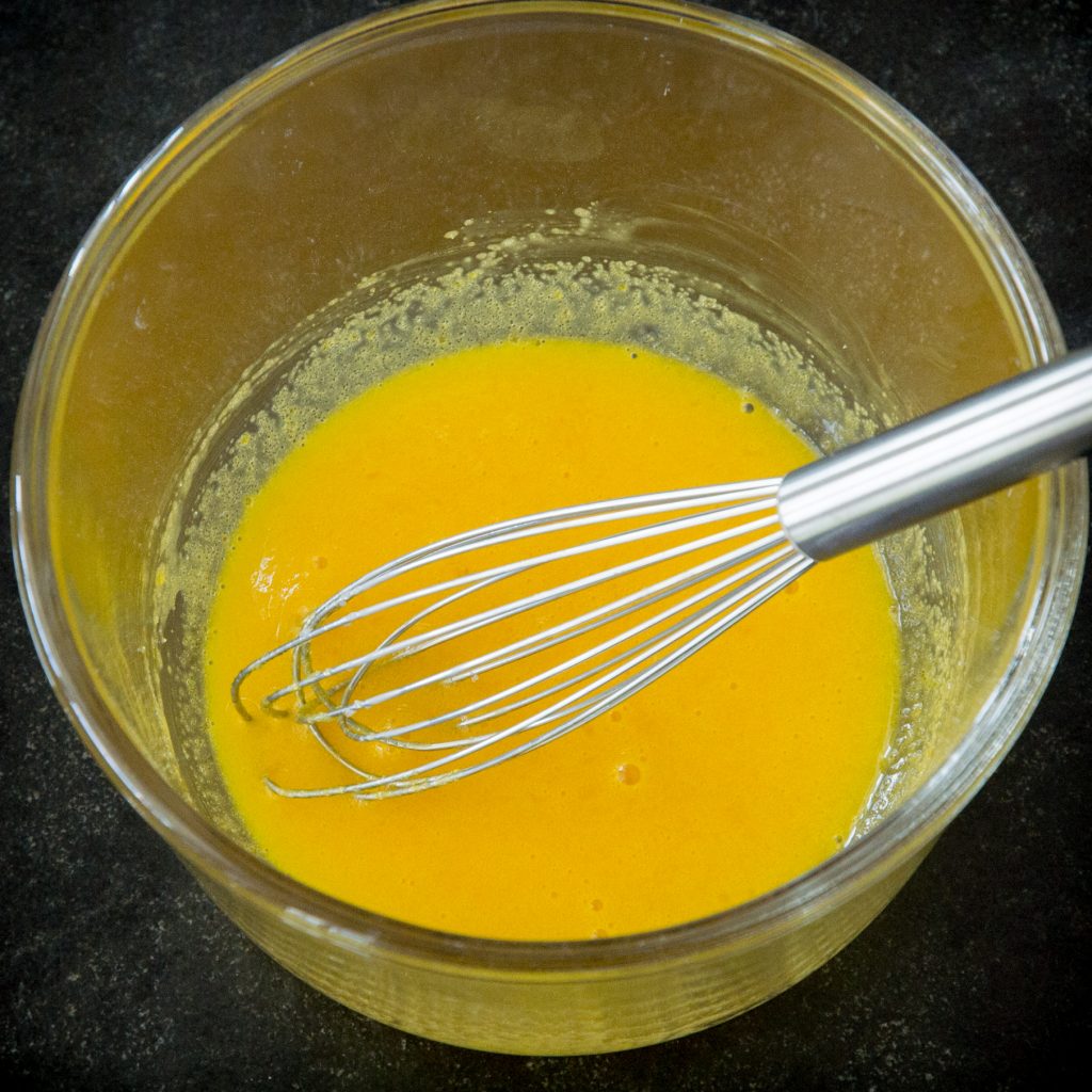Whisking egg yolks in a bowl.