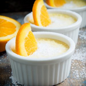 Three bowls of Low-Carb Orange Pots de Crème with a slice of orange on top.