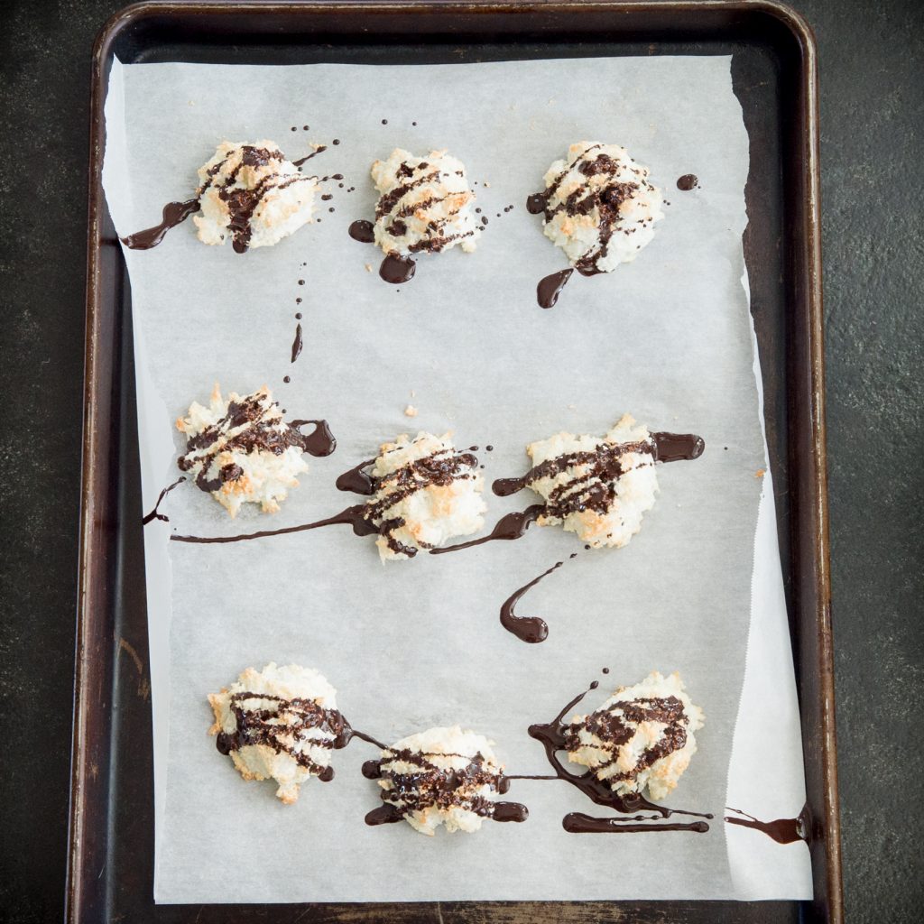 Keto Coconut Macaroons drizzled with chocolate on a tray.