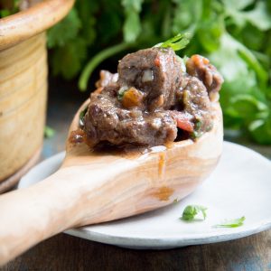 A spoonful of Low-Carb Slow Cooker Mexican Beef Stew resting on a plate.
