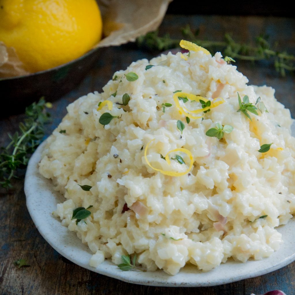Cauliflower risotto garnished with thyme and lemon.