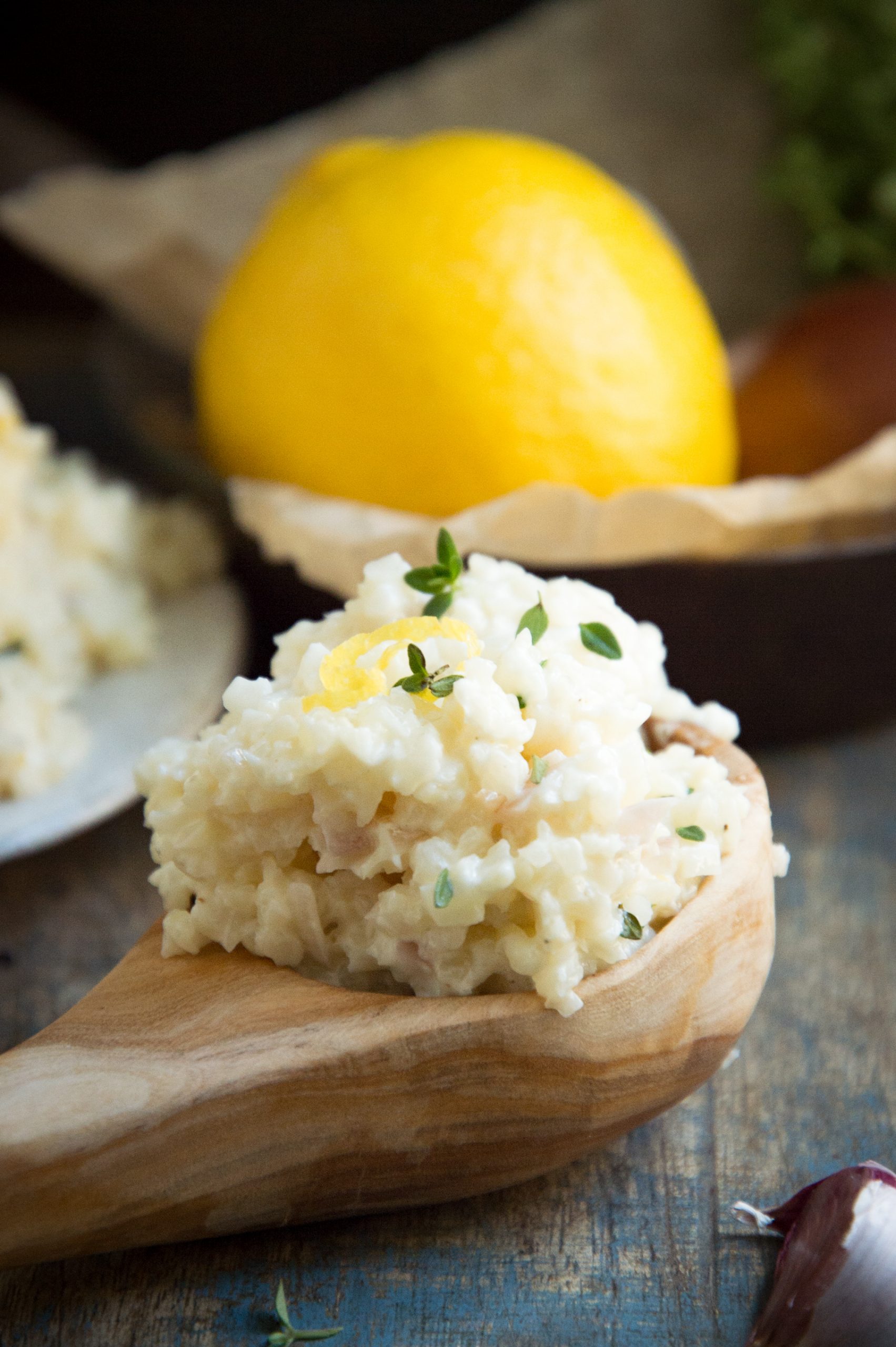 Creamy riced cauliflower on a wooden serving spoon.