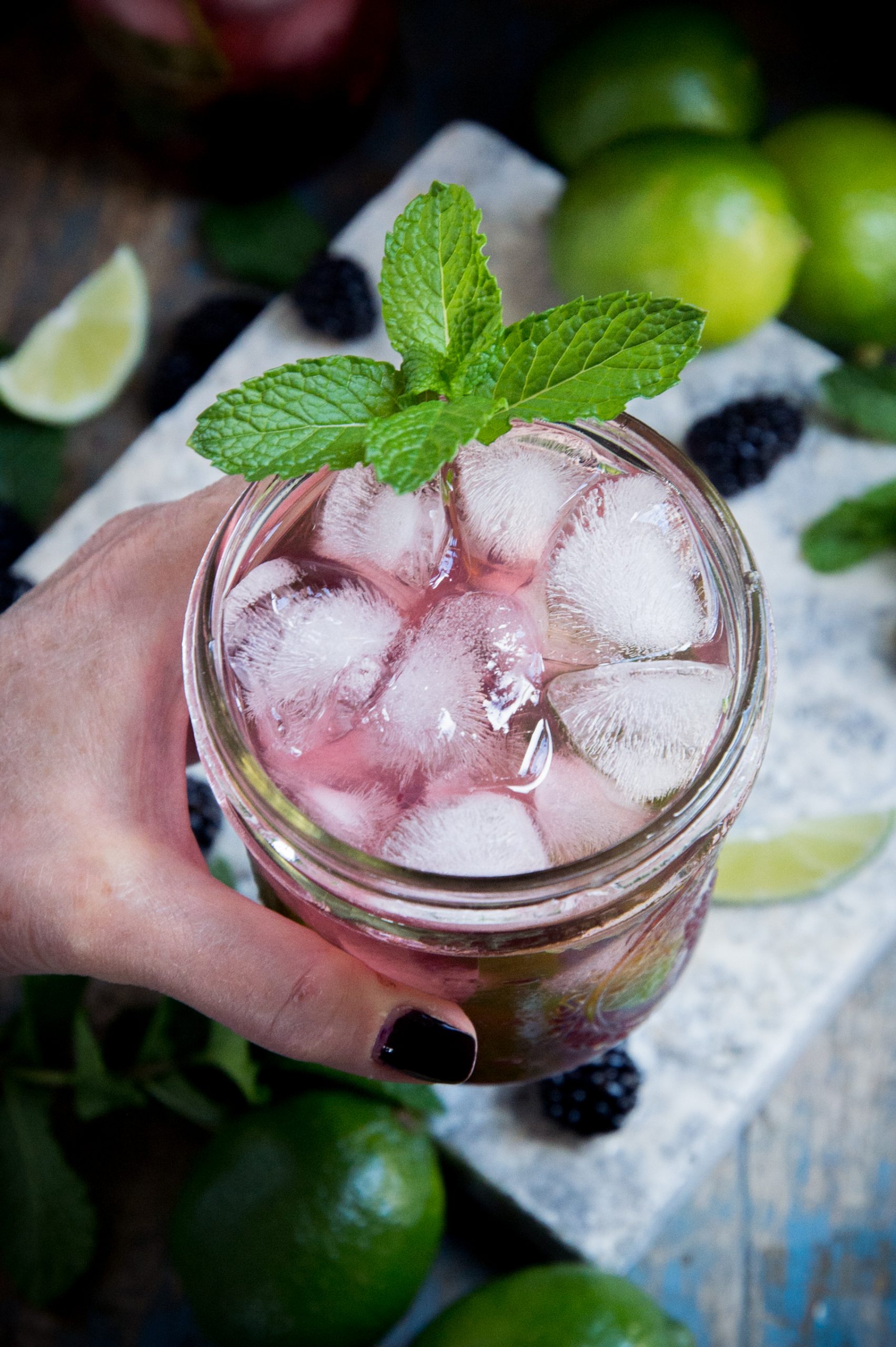 overhead closeup of hand holding low-carb blackberry mojito