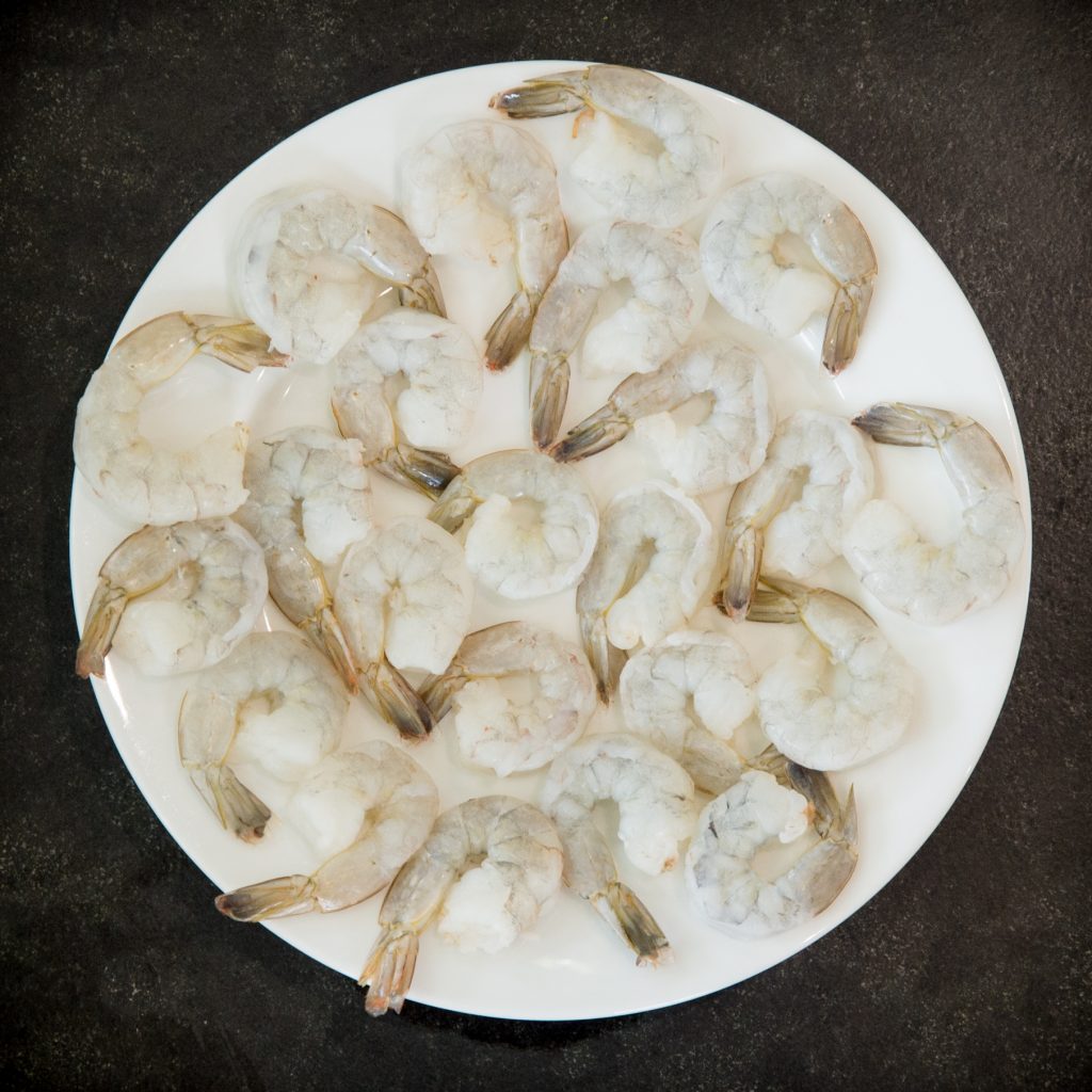 Process photo of raw shrimp on a plate.