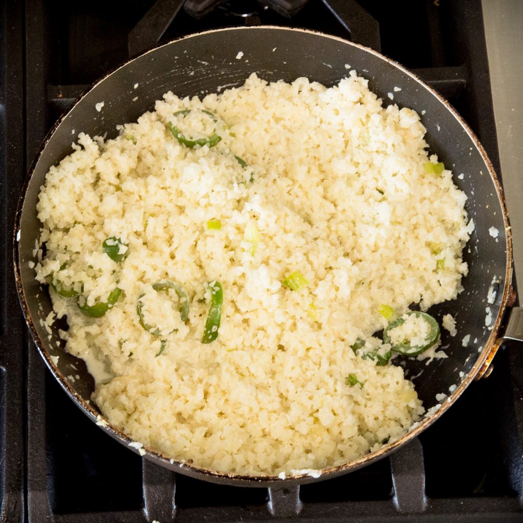 Process photo of grated cauliflower cooking.