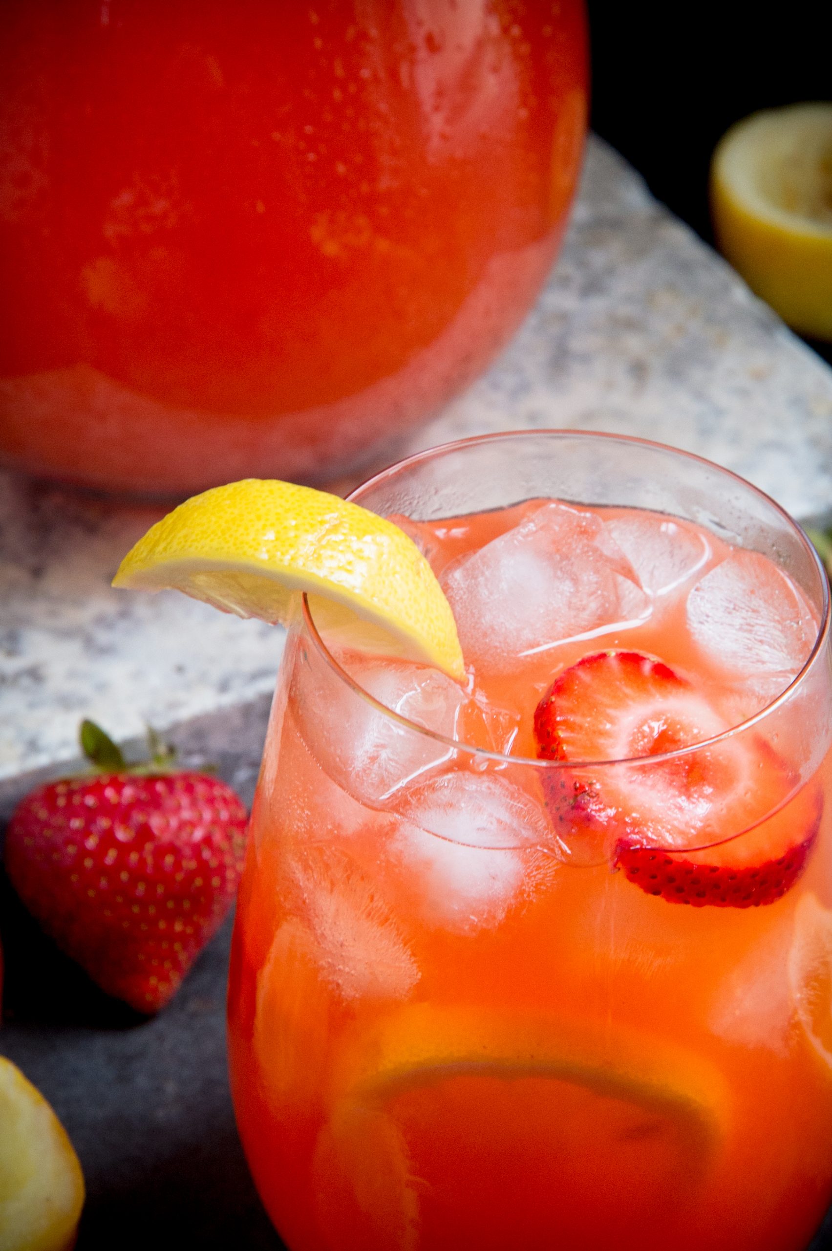 Glass of sugar-free strawberry lemonade in front of pitcher