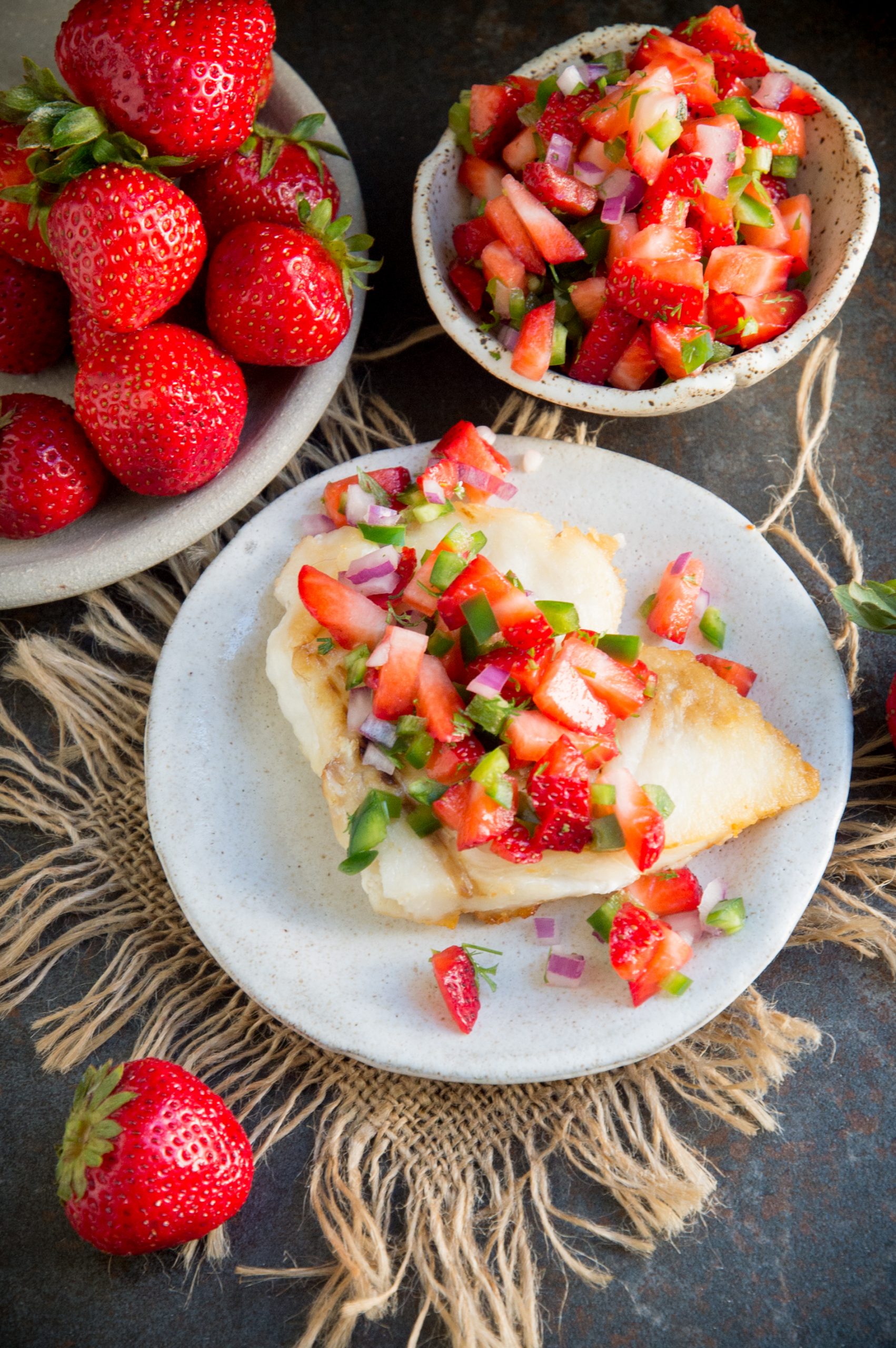 Overhead shot of pan fried fish fillets with strawberry salsa