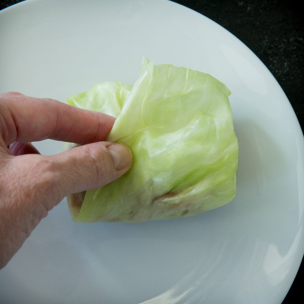 Tucking in the long sides of the cabbage rolls.