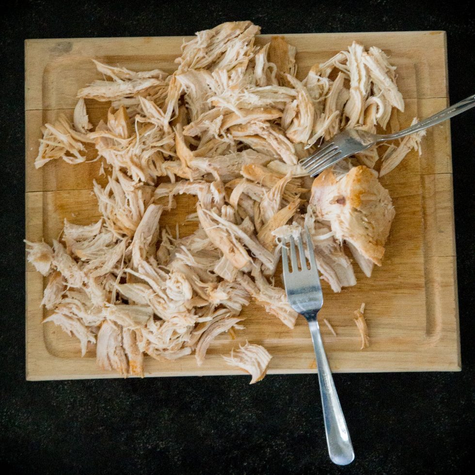 Shredding the chicken with forks.