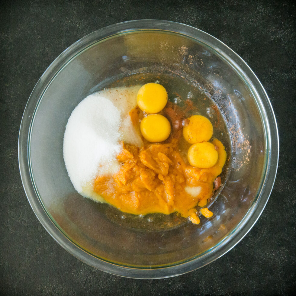 Mixing the pumpkin, HWC, eggs, sweetener, pumpkin spice and salt.