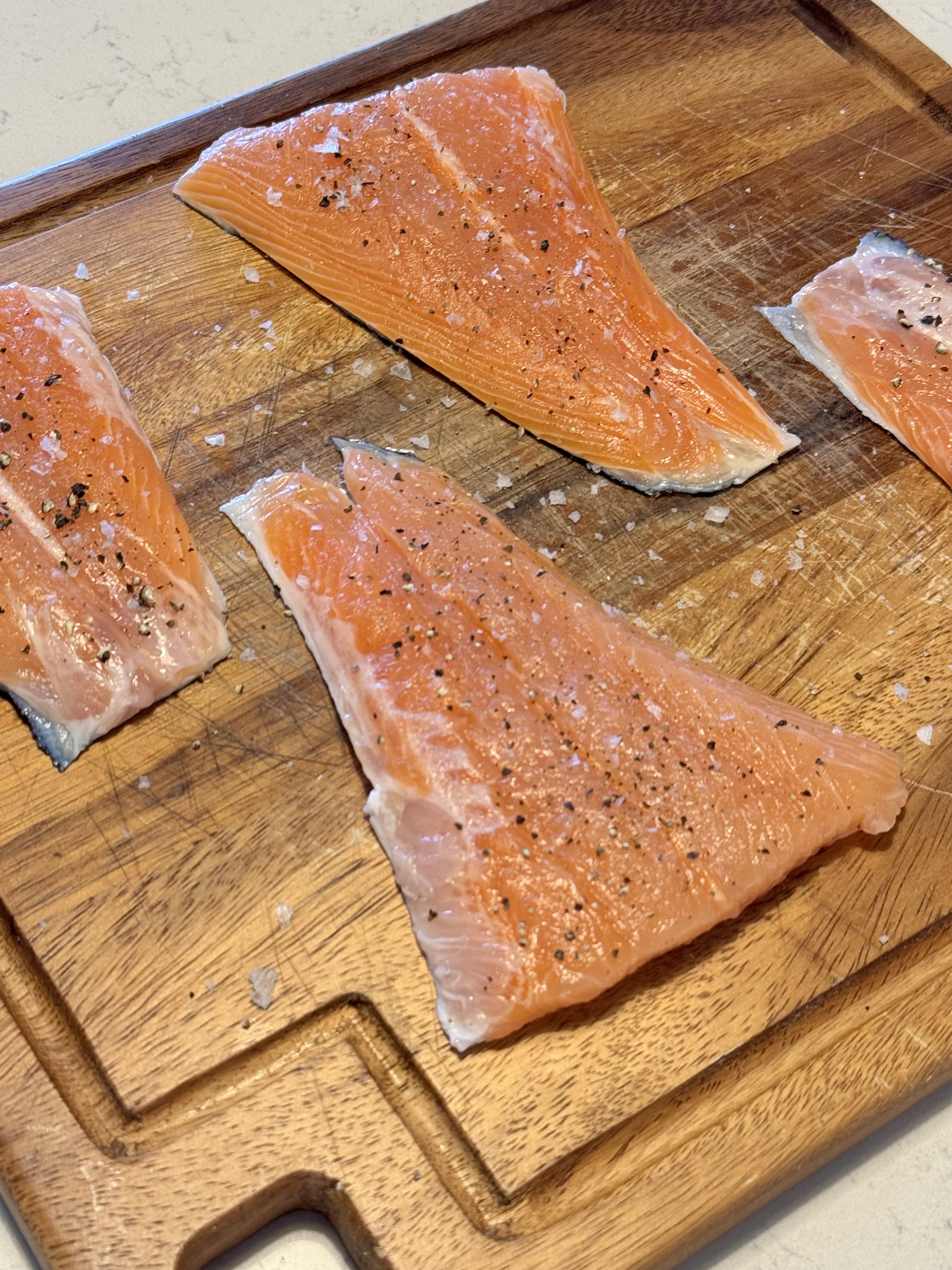 Image of raw salmon, salted and peppered