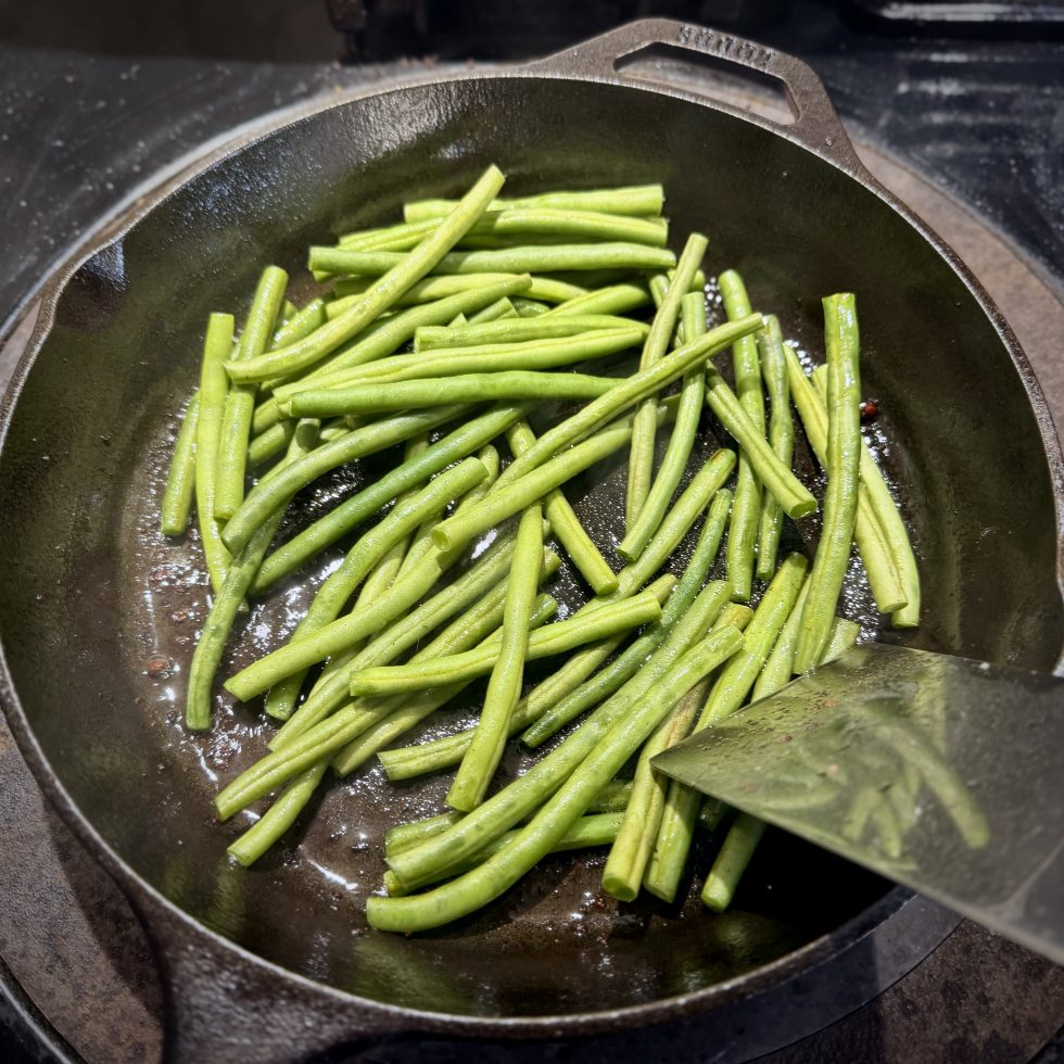 French green beans cooking in cast iron skillet