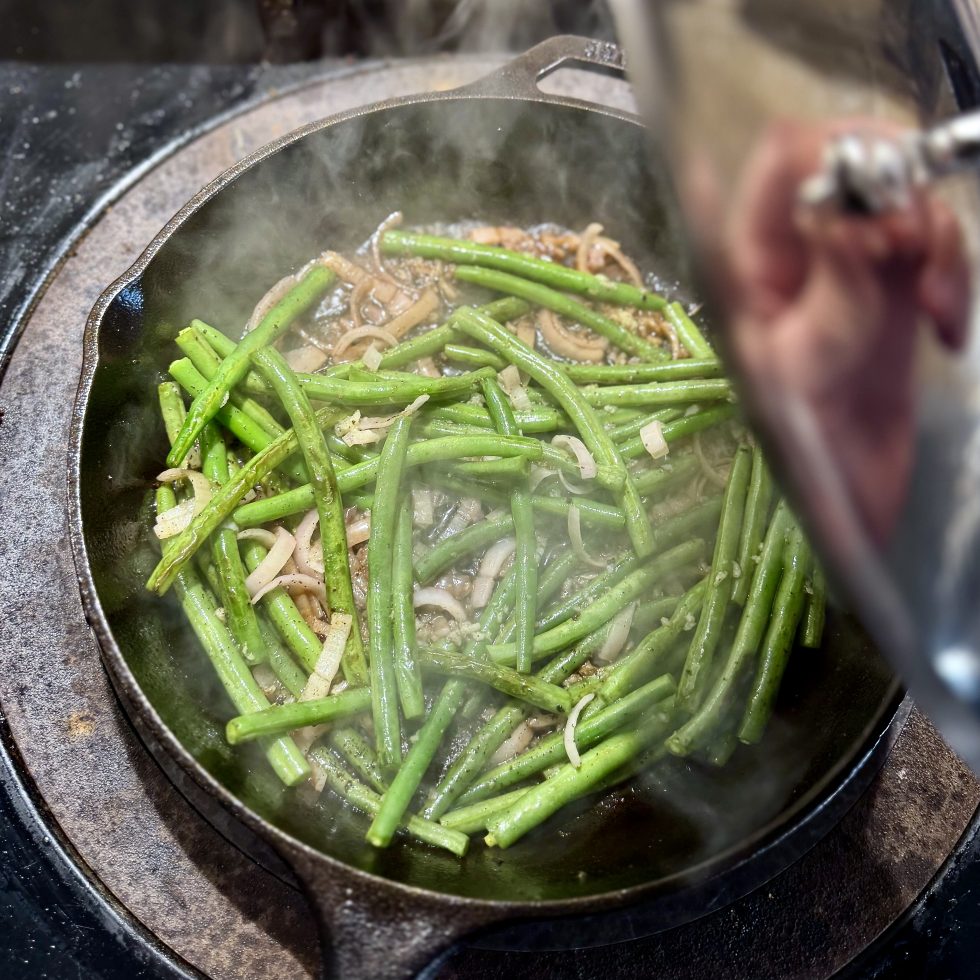 pot of green beans being covered by stainless steel lid
