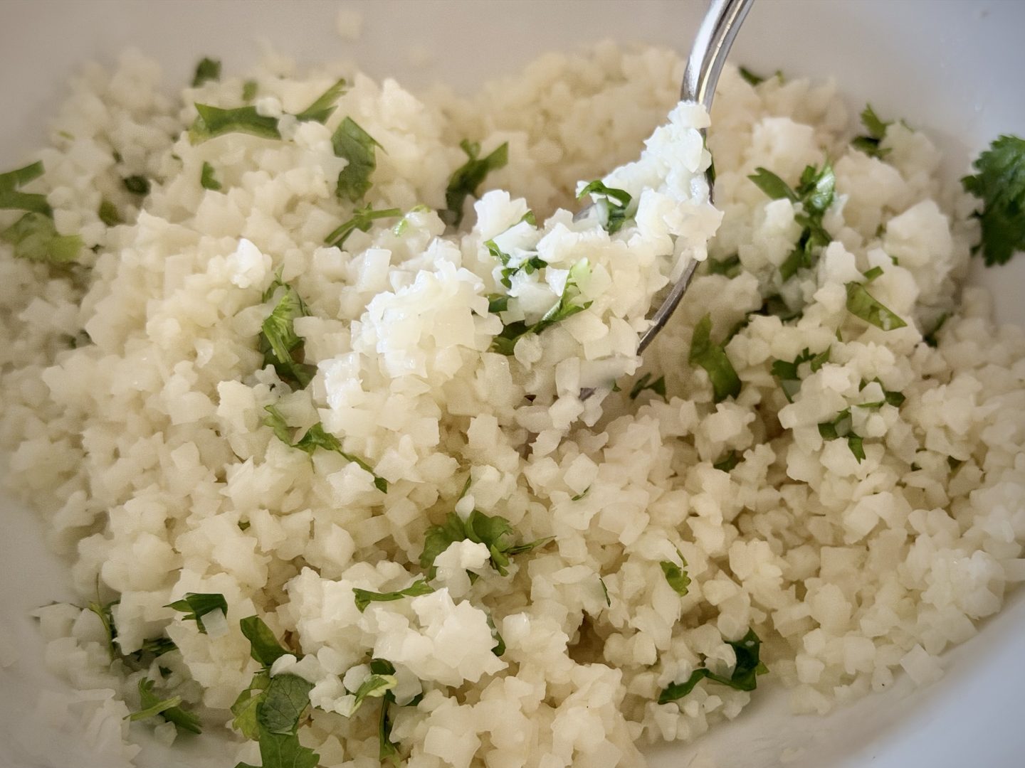 Stirring cilantro into cauliflower rice