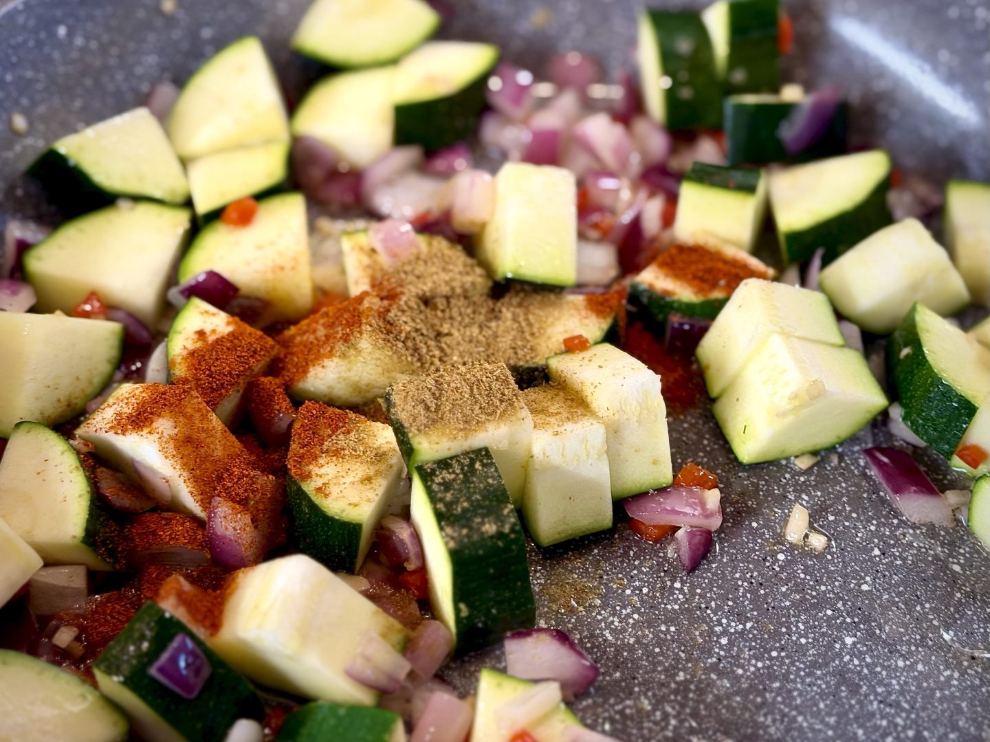 Zucchini, onions, garlic, and spices sautéing