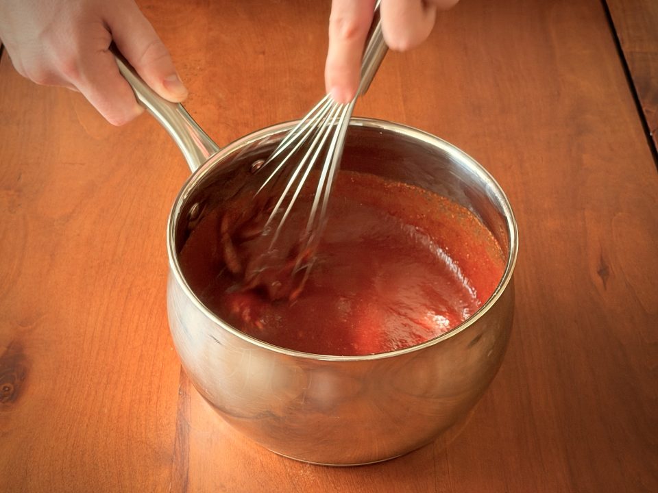 Whisking cold sauce ingredients in a medium saucepan