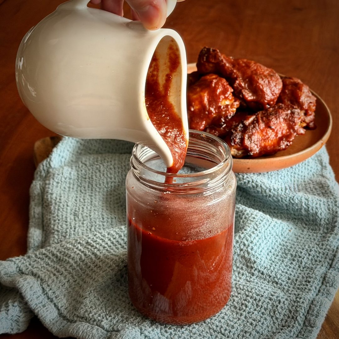 Keto BBQ Sauce being poured into a jar