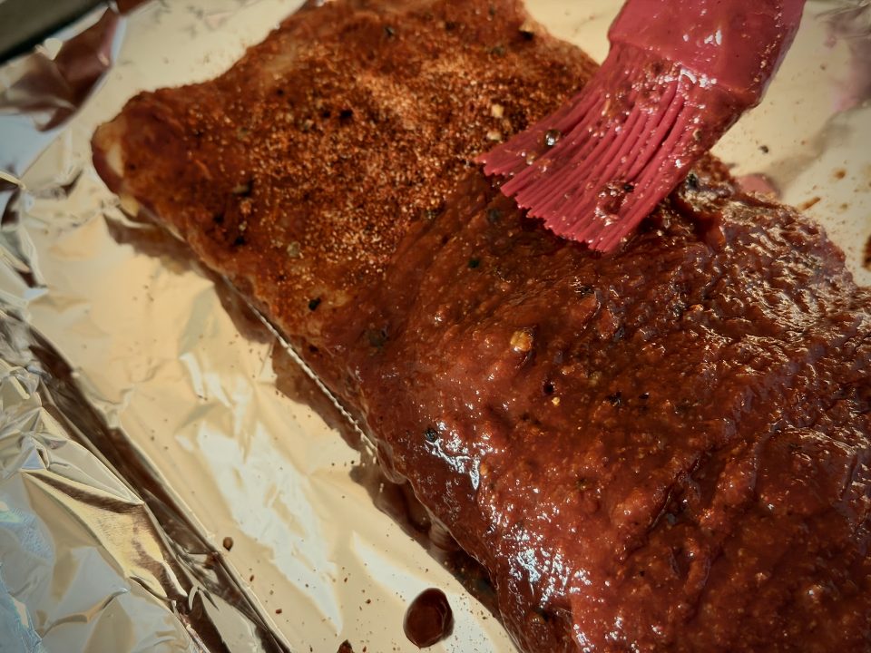 Brushing Sauce onto ribs with a basting brush