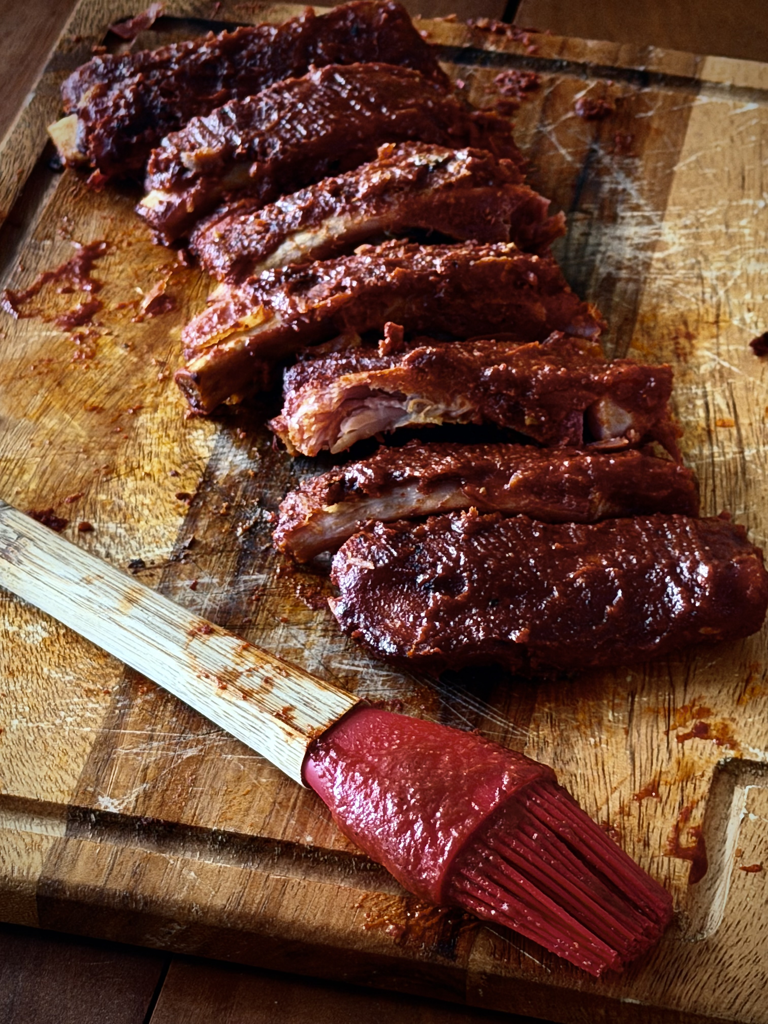 Keto BBQ Ribs sliced and sauced on cutting board